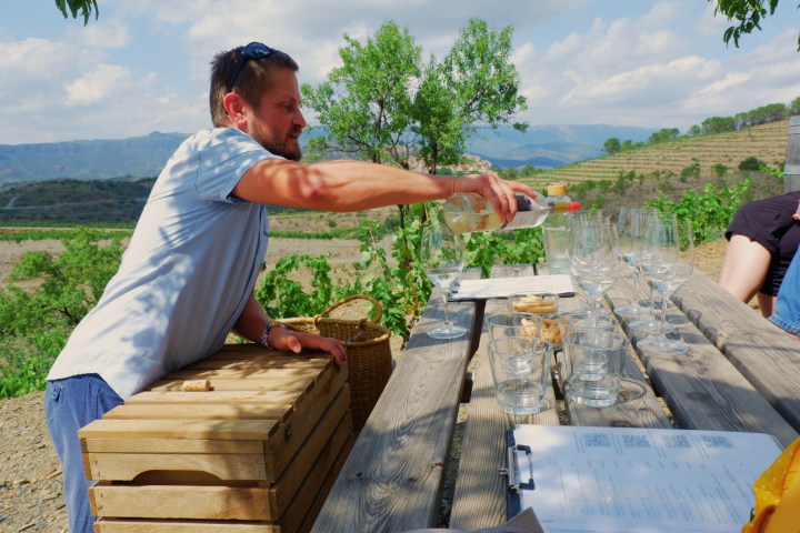 A man puring a glass of white wine