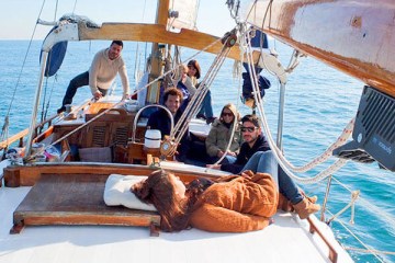 a group of people sitting in a boat on a body of water