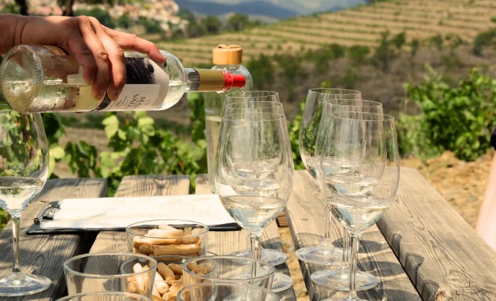 A man puring a glass of white wine