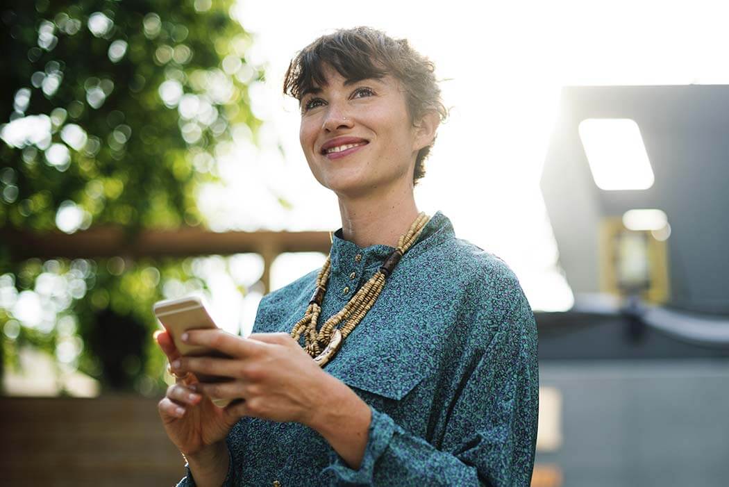 woman-happy a woman holding a cell phone