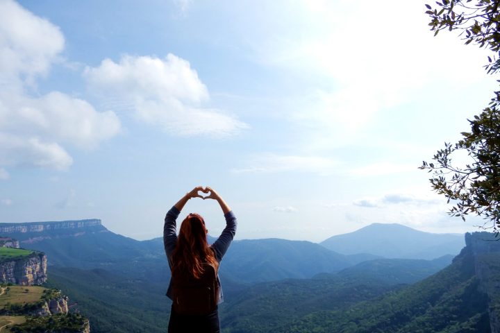 a woman posing for the camera with a mountain in the background