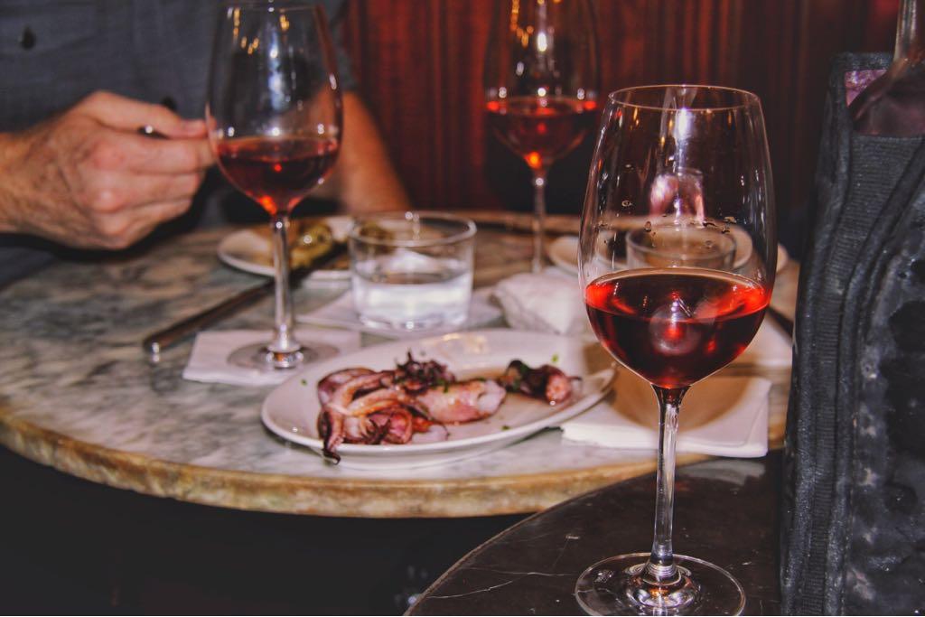 a person sitting at a table with wine glasses