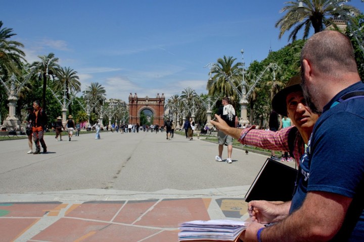 a man standing next to a palm tree
